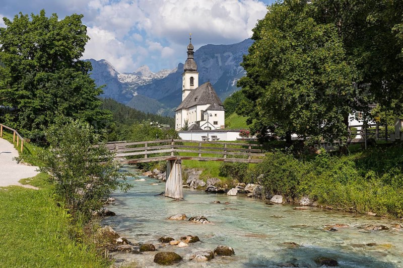 Famous view of the parish church of St. Sebastian with bridge over the Ramsauer Ache in the Ramsauer Malerwinkel with horse-rider Alm and Wagendrischelhorn, Ramsau near Berchtesgaden, Berchtesgadener Land, Bavaria, Germany