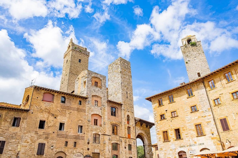 Towers of the old Town with historic buildings from Piazza della Cisterna at San Gimignano on a sunny day, Tuscany, UNESCO World Heritage, Italy, Europe, Europe