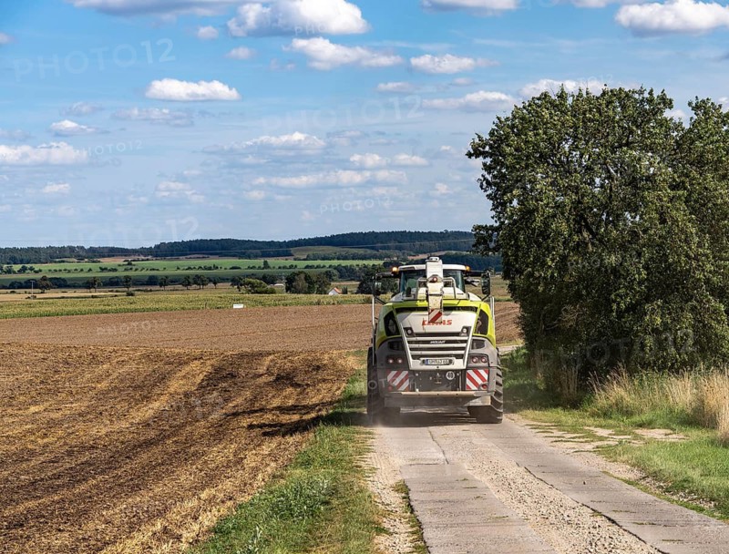 Claas Jaguar 900 series self-propelled forage harvester on a rural path near a harvested field, Uckermark, Brandenburg, Germany