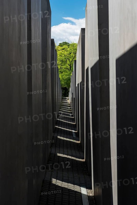 Light and shadow in the corridor of the memorial to the murdered Jews with a view of a green tree, Berlin