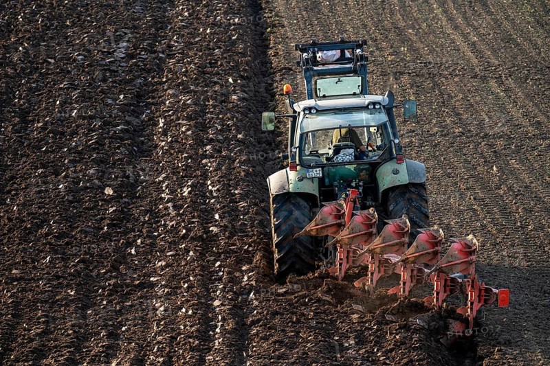 Farmer ploughing a field, tractor with plough, near Neuss, North Rhine-Westphalia, Germany
