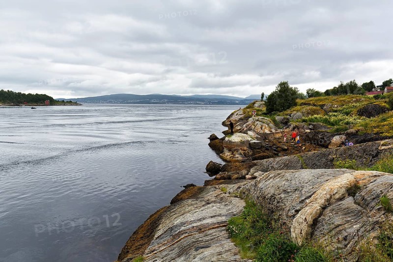 Hikers on the Saltstraumen tidal stream, cloud cover, near Bodo, Northern Norway, Norway
