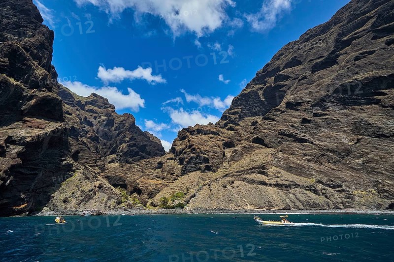 Exit of the Masca gorge, Los Gigantes, impressive rocky gorge with small boats on the sea under a cloudy sky, whale watching boat tour, whale watching, whales, dolphins, west coast, Tenerife, Canary Islands, Spain