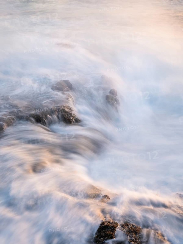 Seawater flows over lava rocks. Long exposure, morning light. Coast near Puerto de Talavera, La Palma, Canary Islands, Spain