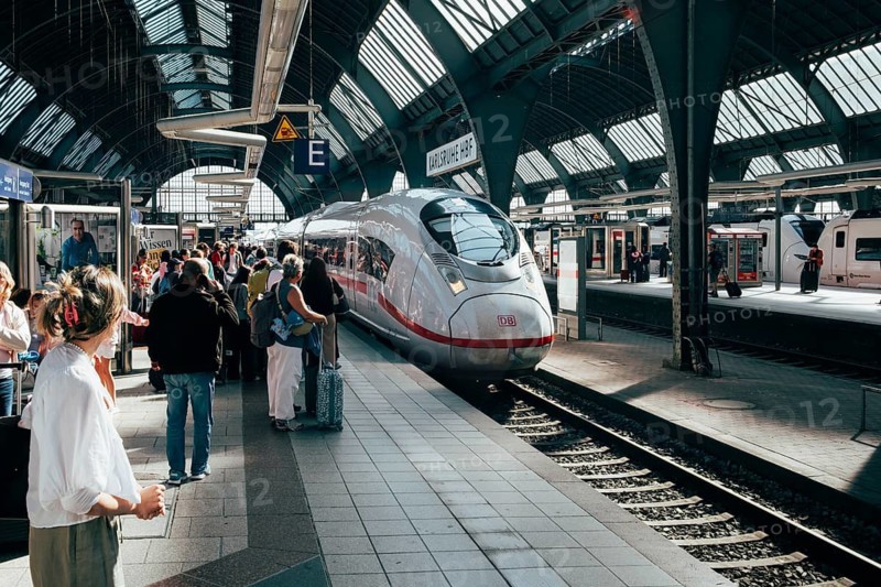 Modern ICE 3 on a platform in the midst of travelers under the characteristic rail hall, station concourse of the headbuilding and transit station. Karlsruhe Central Station, Karlsruhe City District, Baden-Württemberg, Germany