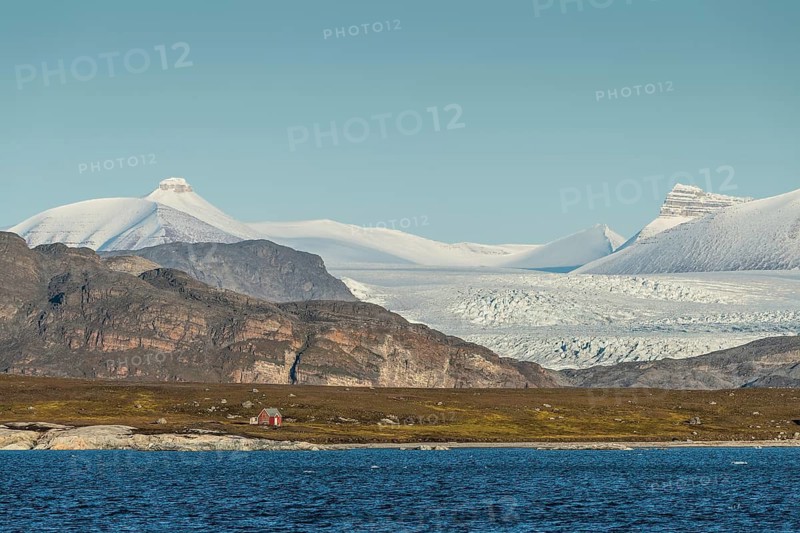A secluded hunting cabin and one of the three mountains: Tee Kroner (Three Crowns), Kronebreen or Kronengletscher Glacier, Kongsfjord or Kongsfjorden, the Svalbard archipelago, Svalbard, Norway