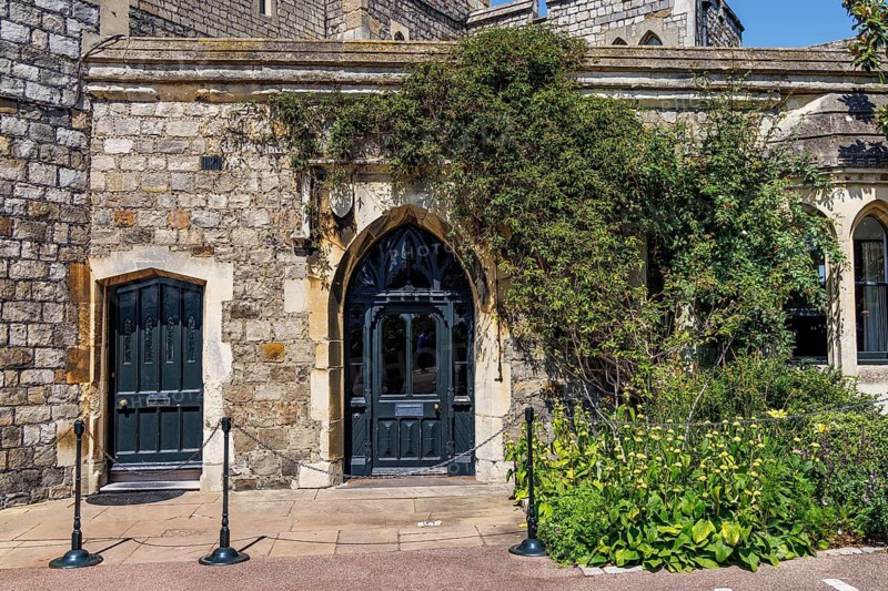 Dark painted doors set within a stone archway mark the entrance to the Winchester Tower, part of Windsor Castle's medieval defensive circuit that has been adapted over successive centuries from fortress stronghold to royal palace, Windsor, England, United Kingdom