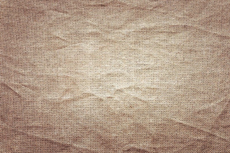 Textured brown fabric with visible creases and folds. The surface appears soft and natural, suitable for backgrounds or textile design
