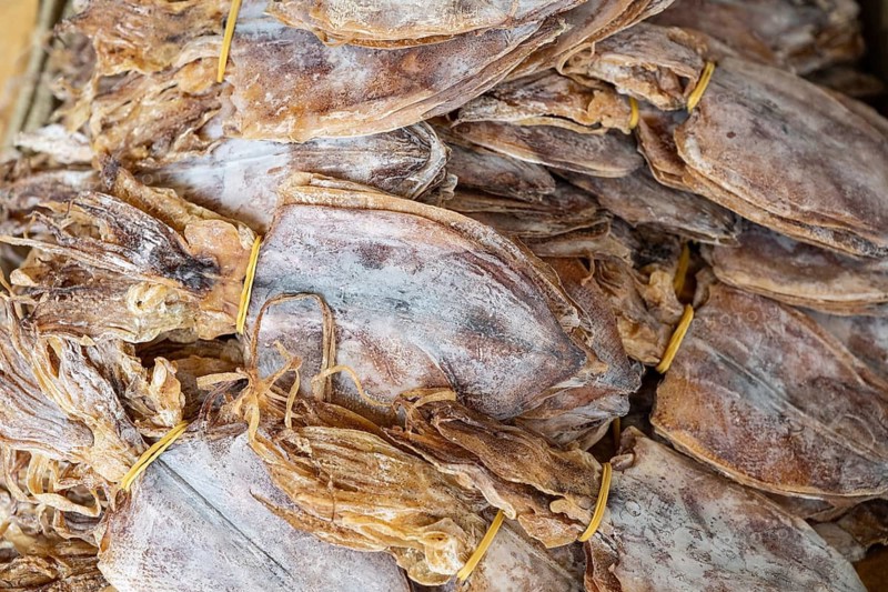 Dried and salted squid on display at a street market stall in Chinatown, Bangkok, a popular destination for eating street food and buying ingredients for Asian cooking. Thailand, Asia