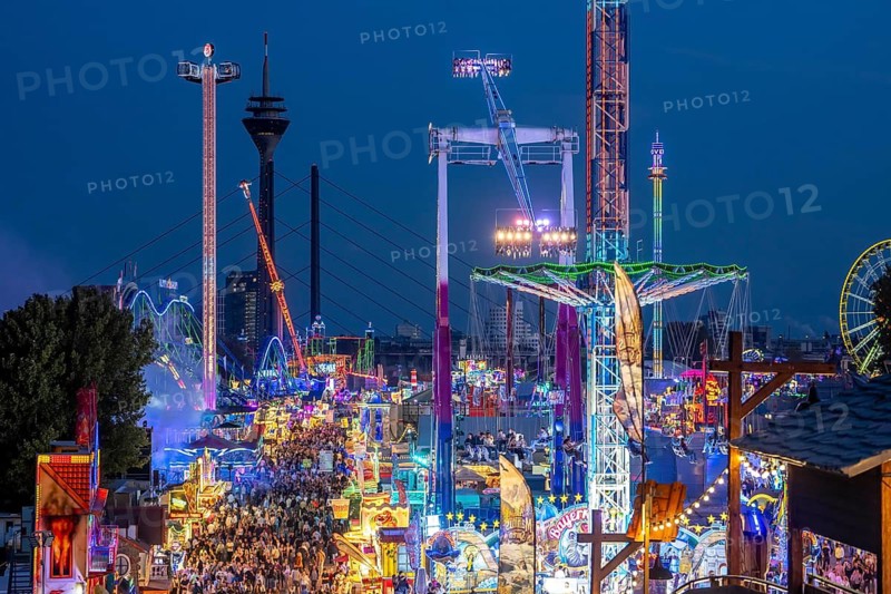 Rhine fair in the Rheinwiesen in Düsseldorf-Oberkassel, view towards the Rhine Tower, Rheinkniebrücke, rides, fairground stands, full corridors, lots of visitors, North Rhine-Westphalia, Germany