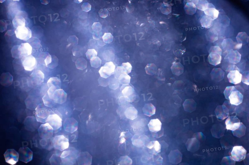Abstract glitter lights textured blue and white background, de-focused, bokeh. Christmas or New Year festive blured sparkling background, winter holidays card concept