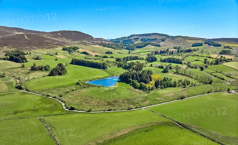 Aerial drone photo of agricultural landscape with meadows and pastures at the border of the Cairn Gorm National Park, Scotland, UK