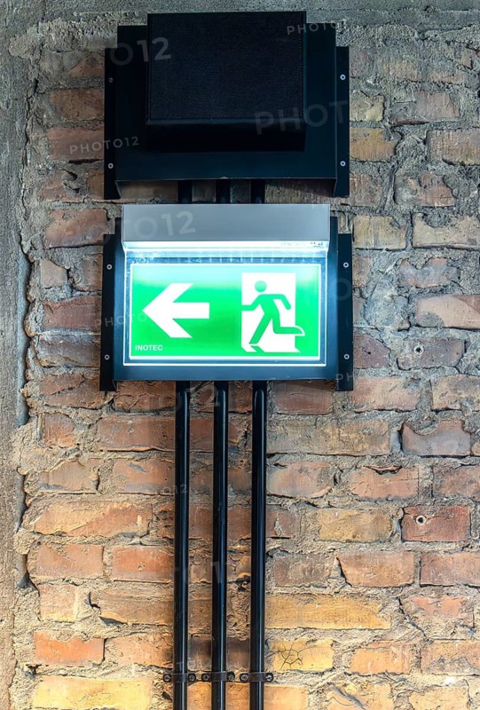 Inotec single-sided LED escape sign light or emergency lighting, wall mounting on brick masonry, Berlin, Germany