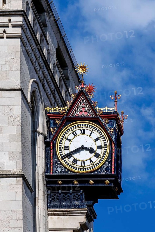 A close view shows the black and gold dial and gilded sunburst finials of the clock on the Royal Courts of Justice, part of George Edmund Street's Victorian Gothic complex on The Strand opened in 1882 as the principal home of England and Wales's senior courts. London, England, United Kingdom