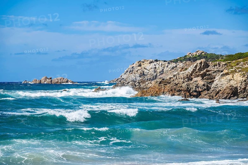 Coastline with emerald green and blue water on a sunny day at Rena Majori beach, Sardinia, Italy