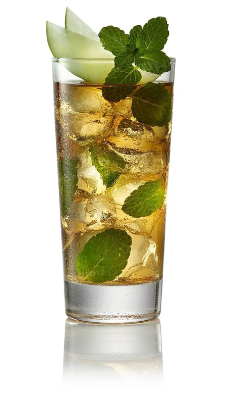 Cocktail on ice cube cubes in a long drink glass against a white background, melon wedges and mint leaves as garnish, studio shot