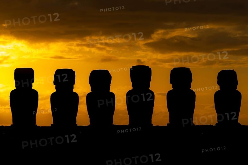 Moai statues as silhouettes in front of an orange sunrise sky, Ahu Tongariki, Easter Island, Chile