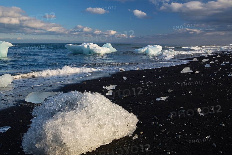 Little icebergs and crushed ice on the black beach at Joekulsarlon glacial lake