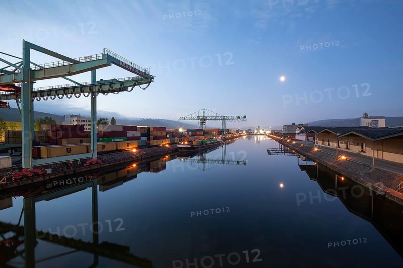 8.5.2026: Container terminal at Stuttgart harbor with cranes and barge under moonlight. Stuttgart, Baden-Württemberg, Germany