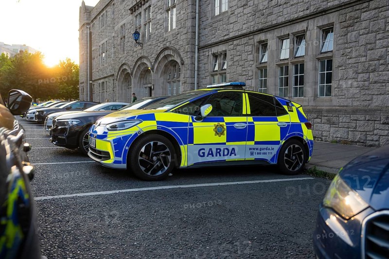 Several police cars in a stone parking lot at dusk, VW ID3, Dublin, Ireland