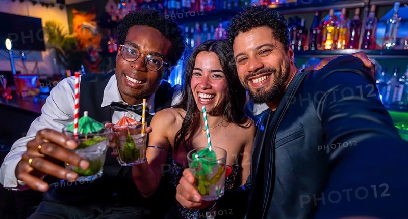 Cheerful multi ethnic friends capturing a joyful selfie while savoring colorful cocktails at a vibrant nightclub, embracing the nightlife