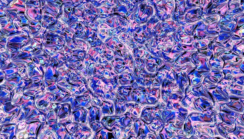 Mesmerizing abstract texture with swirling patterns in shades of blue and pink. The glass-like effect creates a dynamic, fluid appearance, ideal for creative design projects