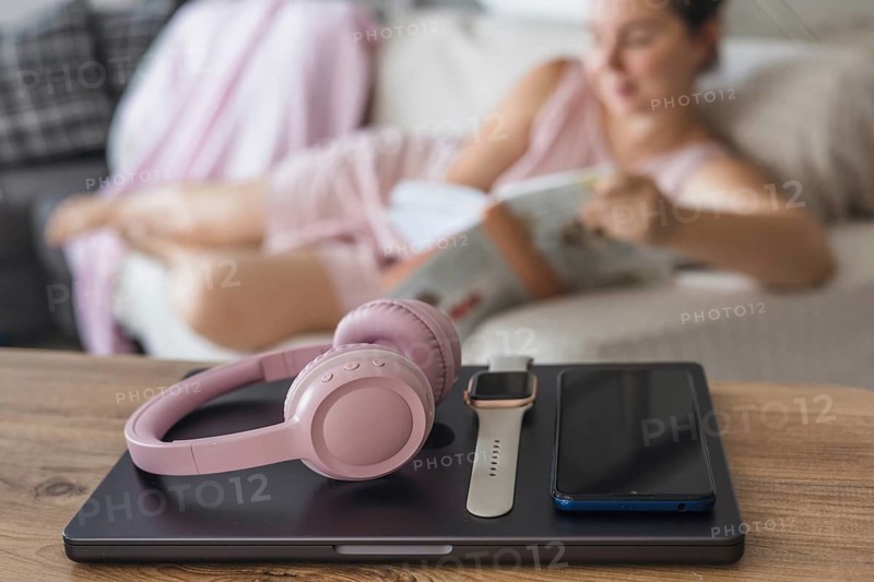 Engaging in a digital detox by relaxing on the couch, reading a book, while enjoying a peaceful afternoon indoors