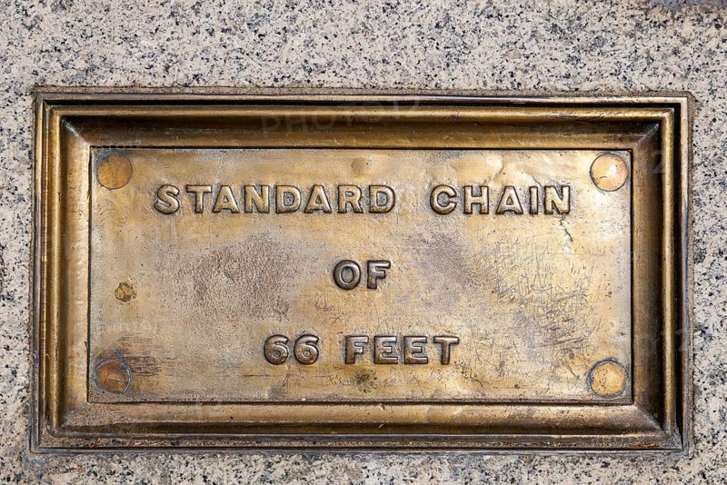 The Standard Chain of 66 Feet plaque is one of the Imperial Standards of Length set into the wall and stairs of Trafalgar Square. Installed in 1876 by the Board of Trade, the surveyor's chain measure underpinned land surveying across Britain. London, England, United Kingdom