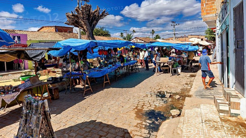 Market stalls under blue skies on a paved street with local natives, market scene in a small town in the Caatinga of Bahia and Pernambuco in Brazil
