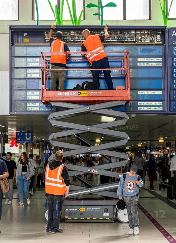 Technicians working on an electronic information board, display board for train connections at Düsseldorf Central Station, North Rhine-Westphalia, Germany