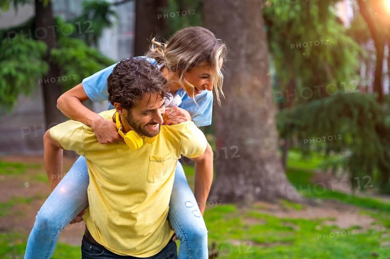 Couple in love in the city at sunset, standing on the back smiling mi having a fun time with each other