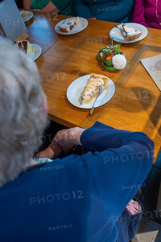 Several people sit at a table in a café, pieces of cake spread on plates, Cafe Kuh, Deckenpfronn, Germany