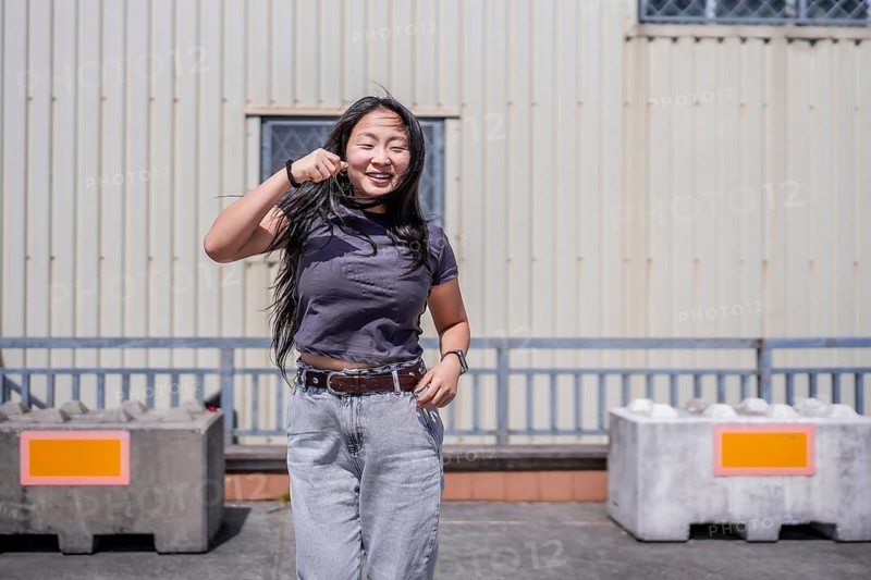 Asian happy girl dancing urban free style in the city in an industrial space outdoors