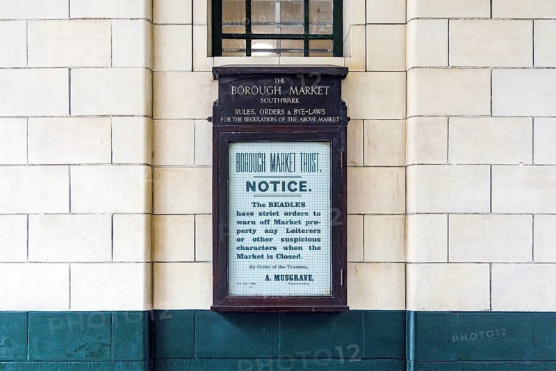 A weathered cast-iron notice board headed Borough Market Southwark sets out rules for the regulation of the market, a reminder of the Trust's long history of governing trading conduct and warning off loiterers when the market gates are closed, London, England, United Kingdom