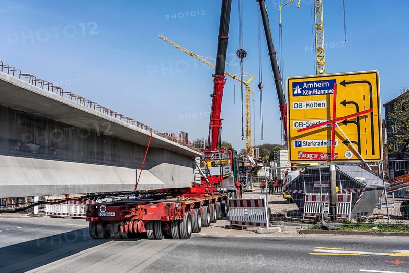 First part of the assembly of the new, 120-meter-long A516 motorway bridge, across Teutoburger Straße in Oberhausen-Sterkrade, 2 large cranes lift the 24 bridge sections weighing up to 121 tons and up to 40 meters long, which are then connected by tendons using a globally unique process, the prefabrication of the bridge parts and the construction process reduces the construction time from 24 to 7 months, per direction, the bridge, built in 1970 was severely damaged, traffic continues to roll on the still existing West Bridge, after which the Completion of this bridge, the western part is also demolished and then rebuilt, traffic rolls in one lane on the new bridge, North Rhine-Westphalia, Germany