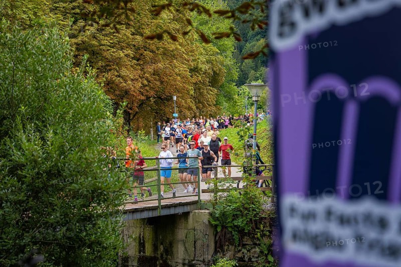 Large group of people at running event crossing a bridge surrounded by green nature, Immenstadt, Allgäu, Germany