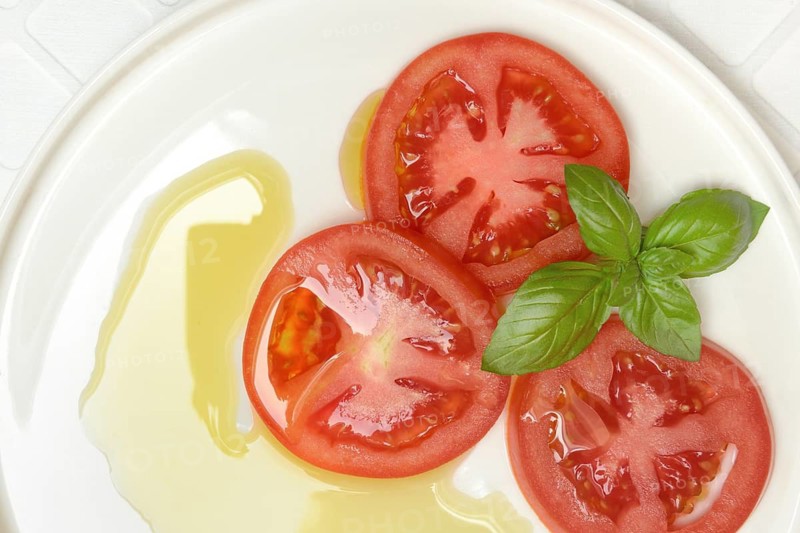 Sliced tomatoes on plate with olive oil