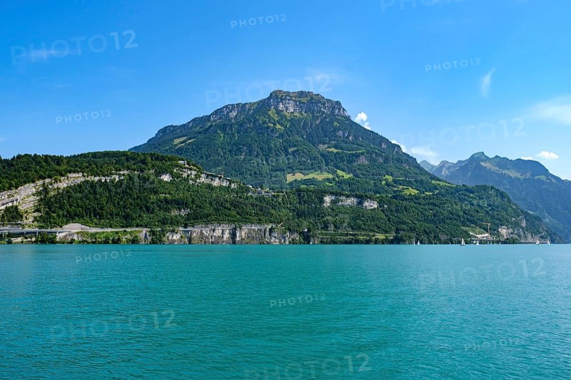 Lake Lucerne in front of an imposing mountain range under a bright blue sky, Seelisberg, Canton of Uri, Switzerland