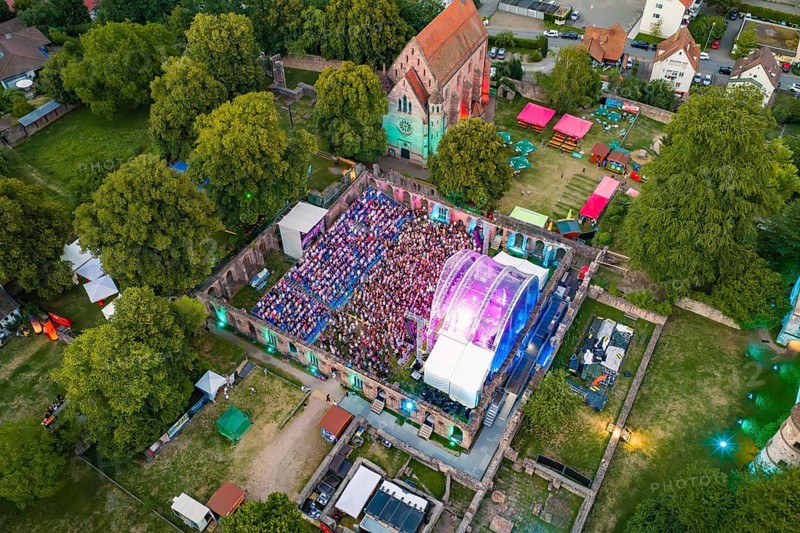 Open air concert with large crowds and colorful lights at night, Calwer Klostersommer Festival, Hirsau Abbey, Calw, Black Forest, Germany