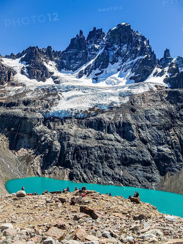 Hikers at the lagoon below mountain Cerro Castillo, view towards glacier and peak Cerro Castillo, nature reserve Cerro Castillo, Reserva Nacional Cerro Castillo, Aysen region, Patagonia, Chile
