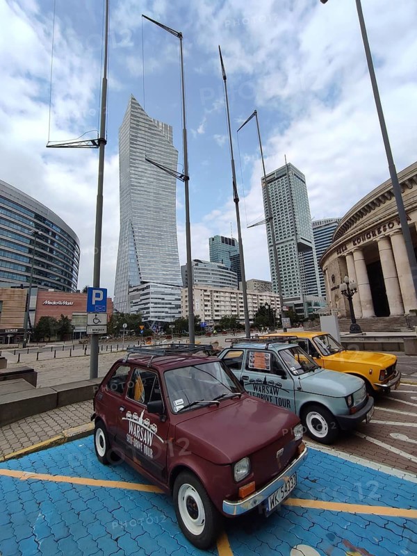 Skyscrapers against cloudy sky, with Fiat 126 cars ready for sightseeing in the foreground and urban flair, Warsaw, Poland