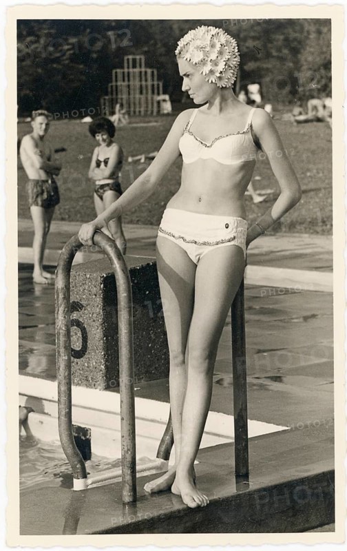 Bathing, swimwear, leisure, summer, outdoor pool, woman standing elegantly at the edge of a pool wearing swimsuit and swimming cap, stylish expression, around 1965