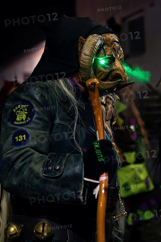 Person with green illuminated carnival mask in mysterious atmosphere, carnival, Schellbronn night parade, Schellbronn, Germany