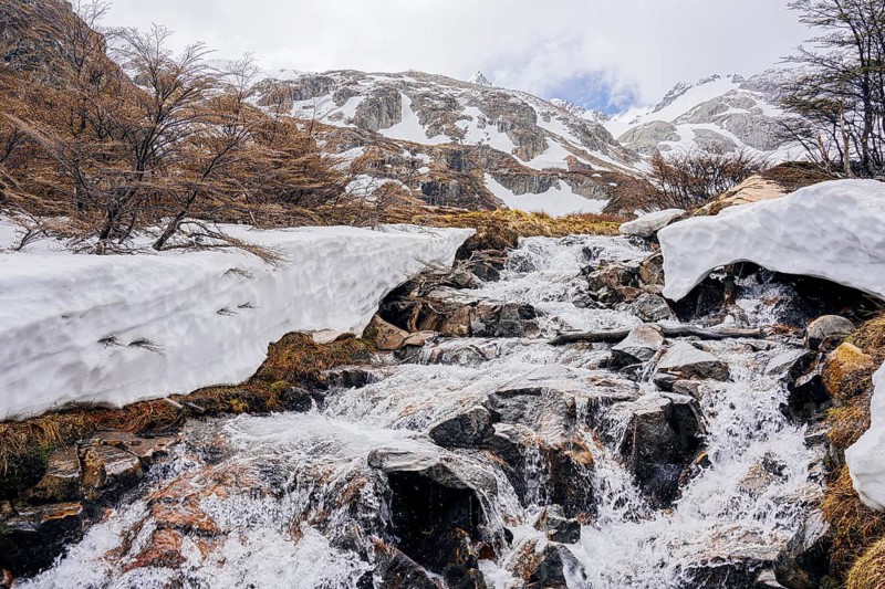 Glacial river, Glaciar Vinciguerra, Ushuaia, Tierra del Fuego Province, Argentina, Kleiner Wasserfall über Steine mit Schnee und vereisten Bereichen, Argentinien