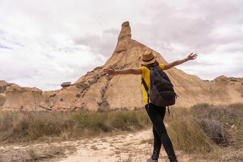 Free woman raising arms standing in an arid national park area