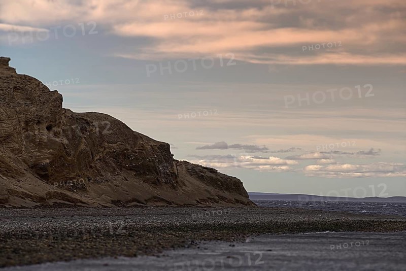 The rock of the island Isla Magdalena, the penguin colony in front of a cloudy sky, Punta Arenas, Chile