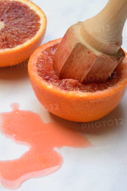 Halved blood orange with citrus squeezer, orange