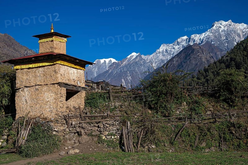 Small Buddhist Torstupa in front of snow-capped mountains of the Siringi Himal mountain range, Tsum Valley, Himalayas, Nepal