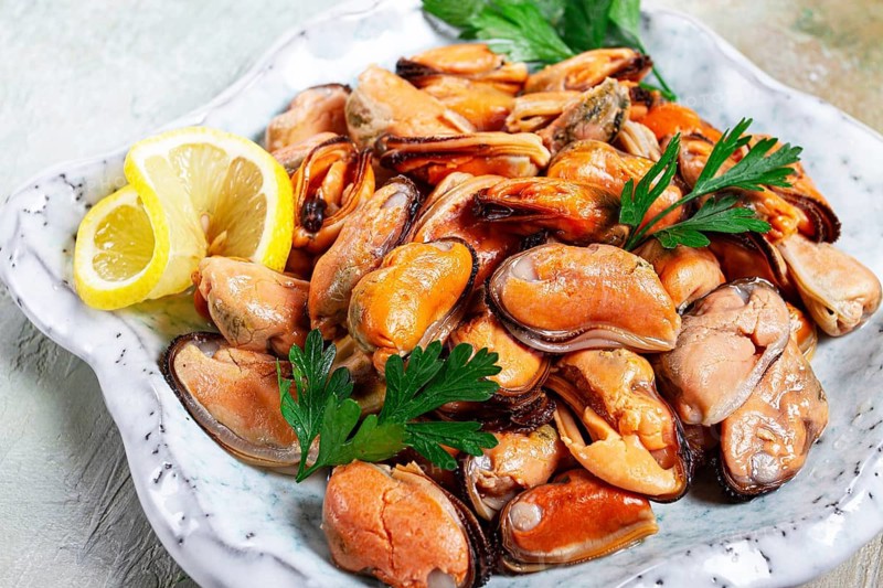 Mussels no shell, boiled, mussels, peeled, in a bowl, with lemon and parsley, Chilean mussels, top view, no people