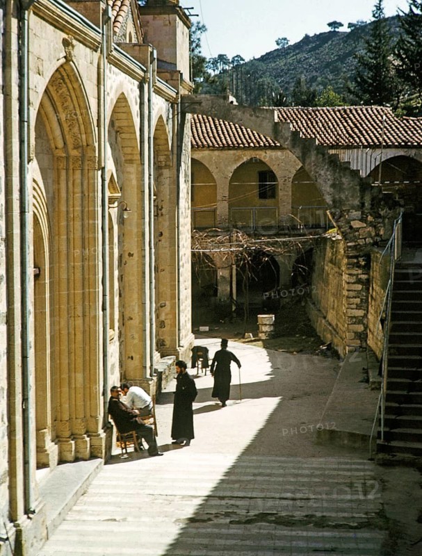 Mönche und andere Menschen sitzen vor der Kirche des Klosters Panagia Machairas, Lazanias, Zypern, 1963